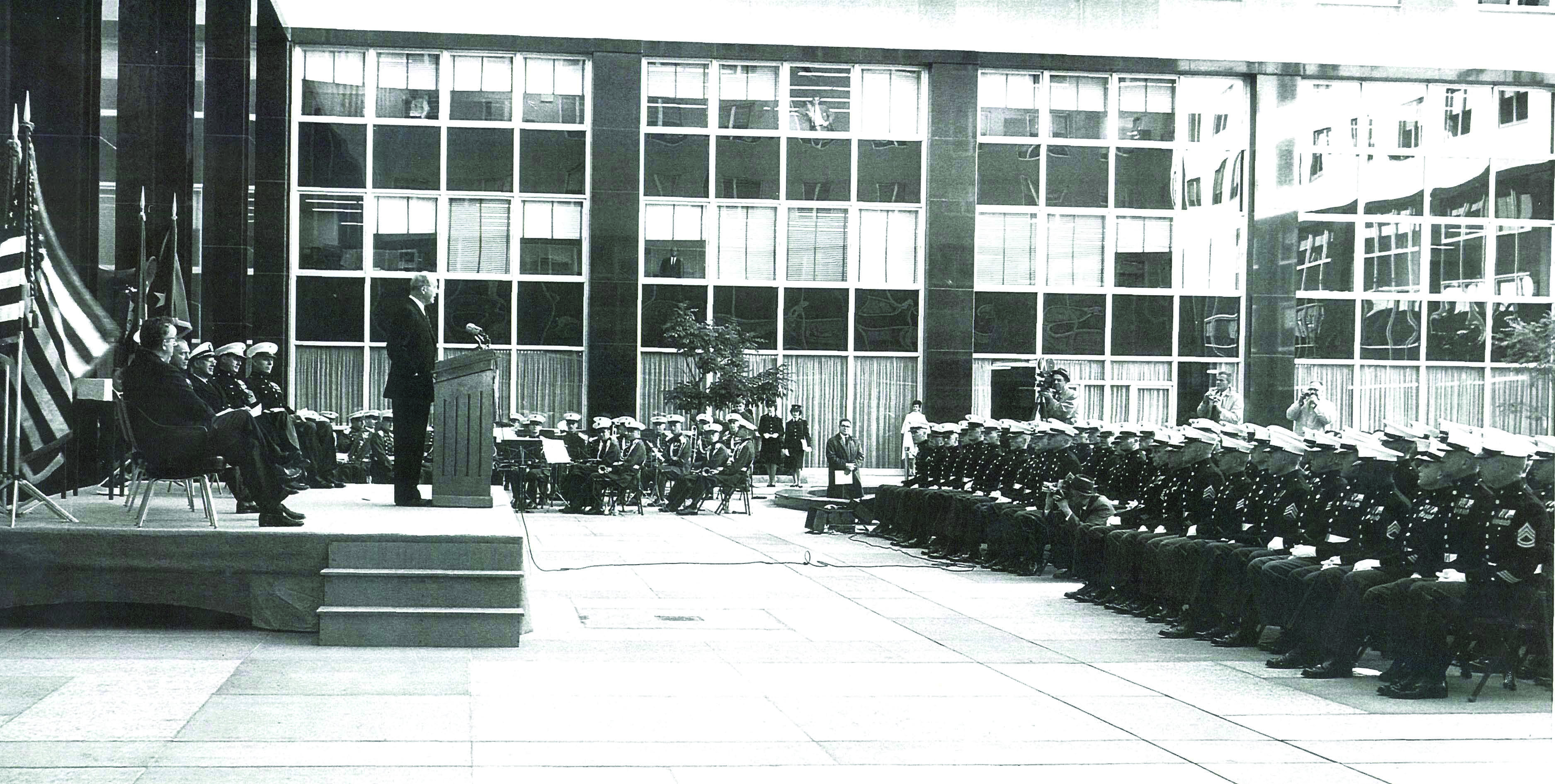 Secretary of State Dean Rusk speaks to a graduating class of Marine Security Guards (MSG). During the 1950s, the Department and the Marine Corps made significant changes to the MSG training program, including the addition of an on-the-job component (at Main State) and the development of a Marine Security Guard Handbook. Source: Department of State Records, National Archives and Records Administration.
