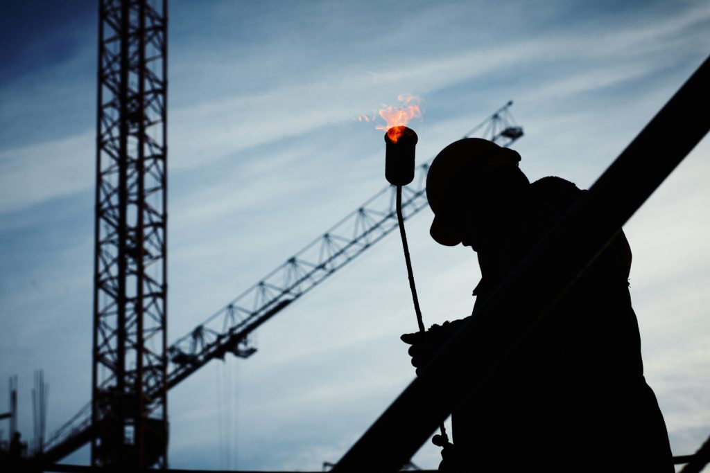 Silhouette of a man holding welding equipment at a construction site. (Yury Kim, 2008)