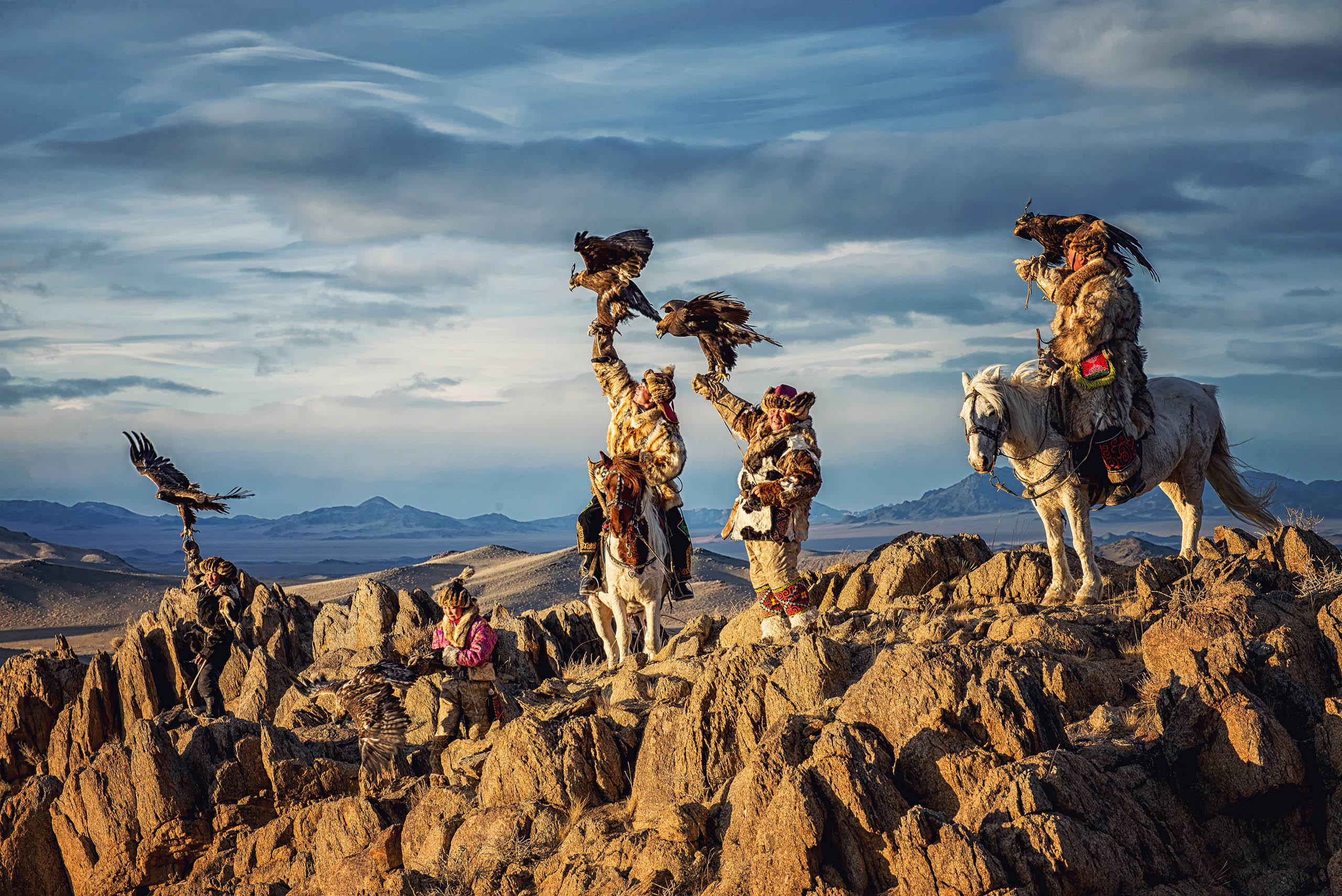 Mongolian eagle Hunters in traditionally wearing typical Mongolian Fox dress culture of Mongolia on Altai Mountain background at Ba-yan UiGII, MONGOLIA