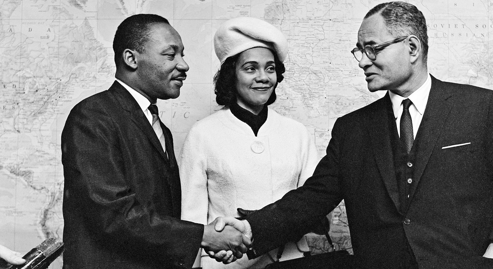Ralph Bunche shakes hands with Martin Luther King, Jr. as he greets him and Coretta Scott King in 1964.