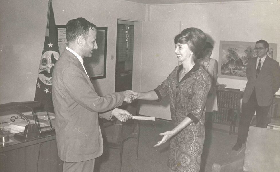 Earlier in her career before becoming a special agent, Patti Morton, pictured right, is presented with a Meritorious Step Increase award by the Chief of Mission in Kinshasa, 1968. (Collection of the National Museum of American Diplomacy)