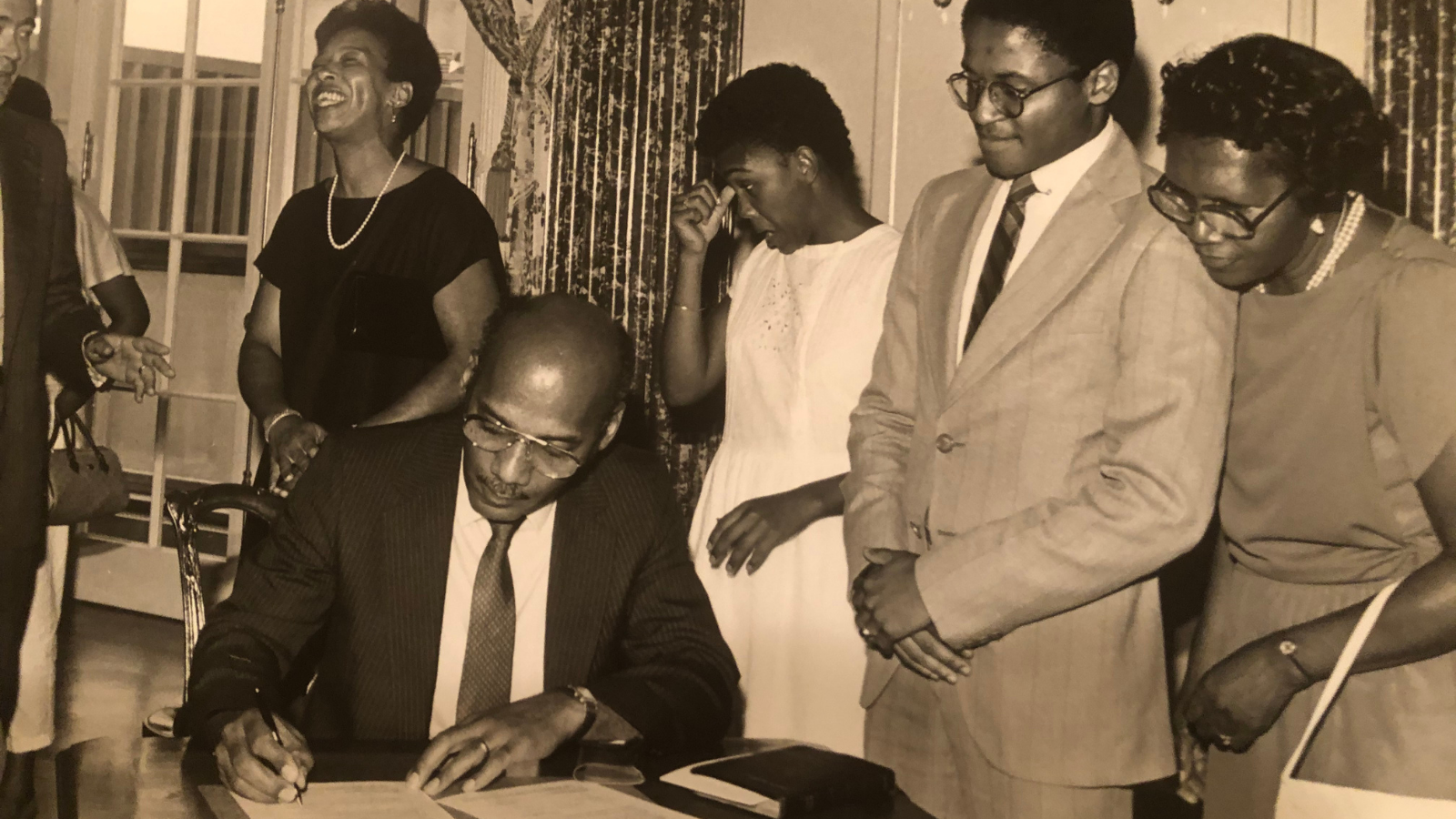 Irv Hicks Jr., along with the Hicks family, witnesses his father, Irvin Hicks, Sr. sign the papers to serve as U.S. Ambassador to Seychelles in 1985. This was Hicks Sr.’s first of three ambassadorships, including the Seychelles, Deputy Representative to the UN, and Ethiopia.