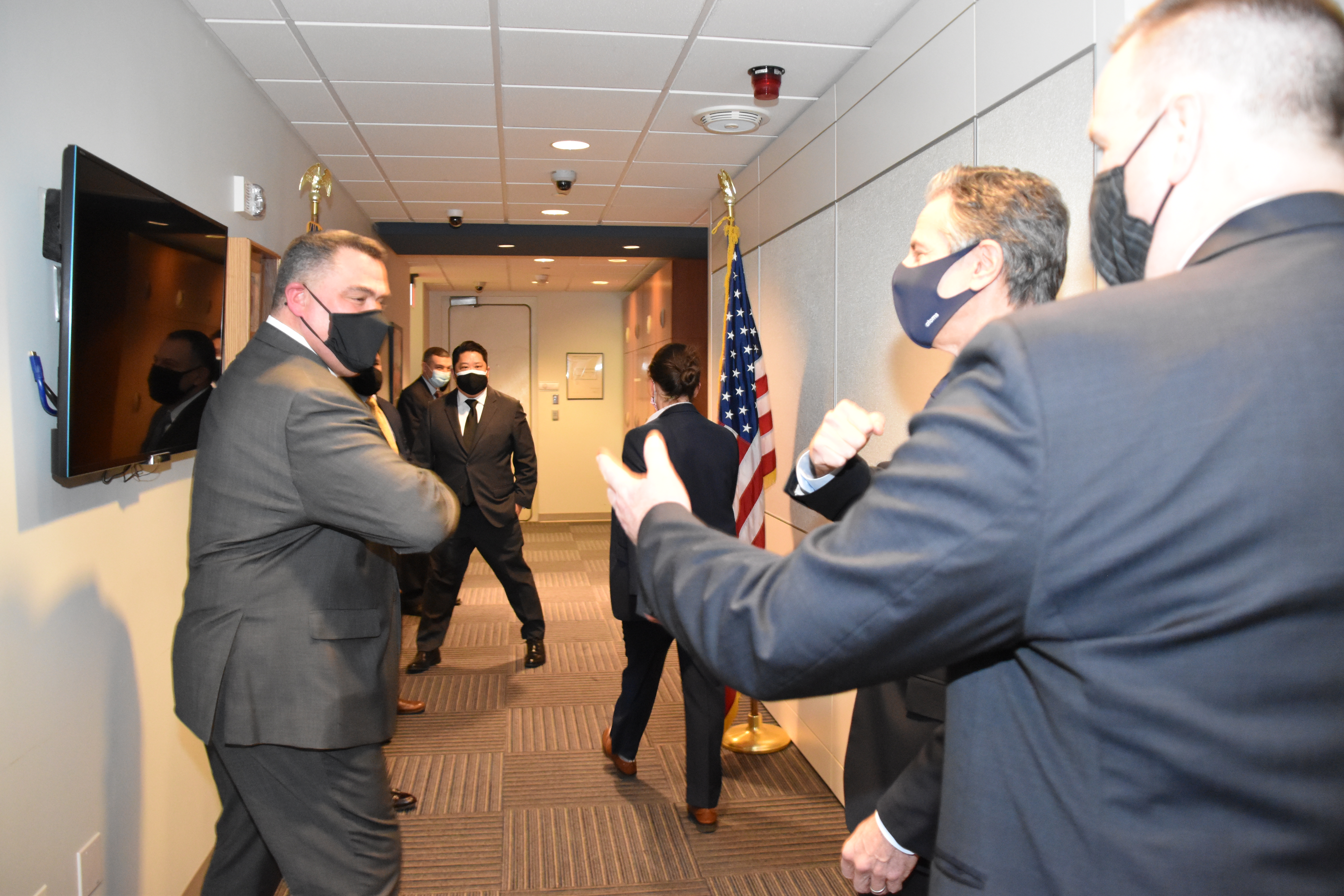 Acting Assistant Secretary of State for the Bureau of Diplomatic Security Todd J. Brown (far right) introduces Secretary of State Antony J. Blinken (second from right) to Acting Director of the Diplomatic Security Service Carlos F. Matus (front, far left), who welcomes Secretary Blinken to the DSSCC with an elbow bump, Arlington, Va., February 21, 2021. (U.S. Department of State photo)