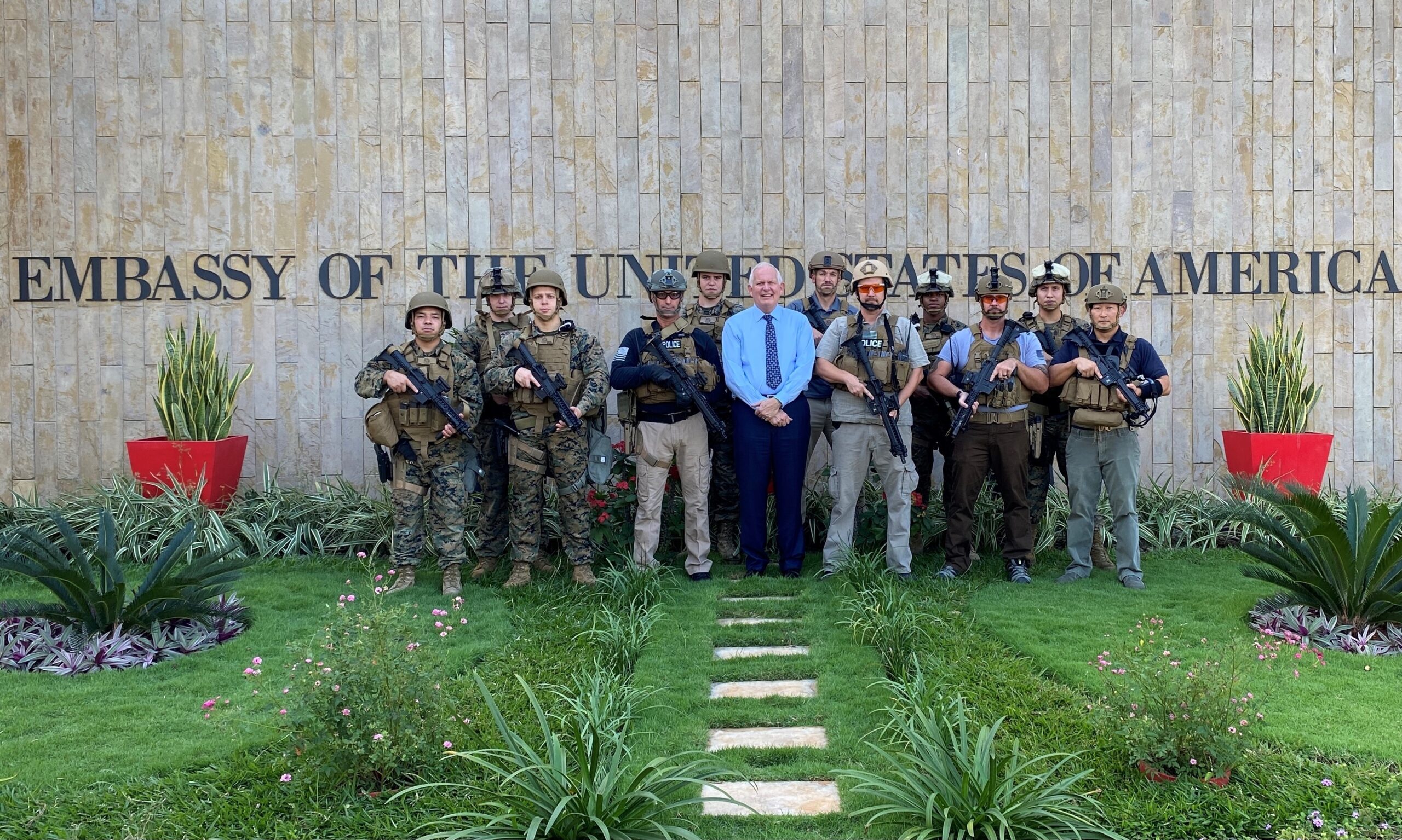 DSS special agents and Marine Security Guards pose with U.S. Ambassador Donald Wright (center, wearing blue shirt) outside the U.S. Embassy following the completion of a bomb scenario exercise, Dar es Salaam, Tanzania, July 6, 2021. (U.S. Department of State photo)