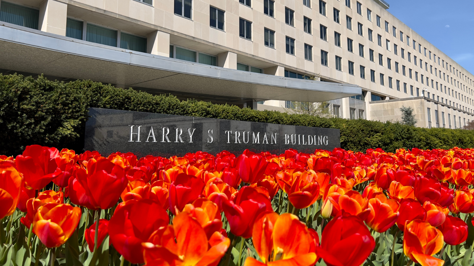 Pictured is the main entrance of the Harry S Truman building with a bed of tulips.