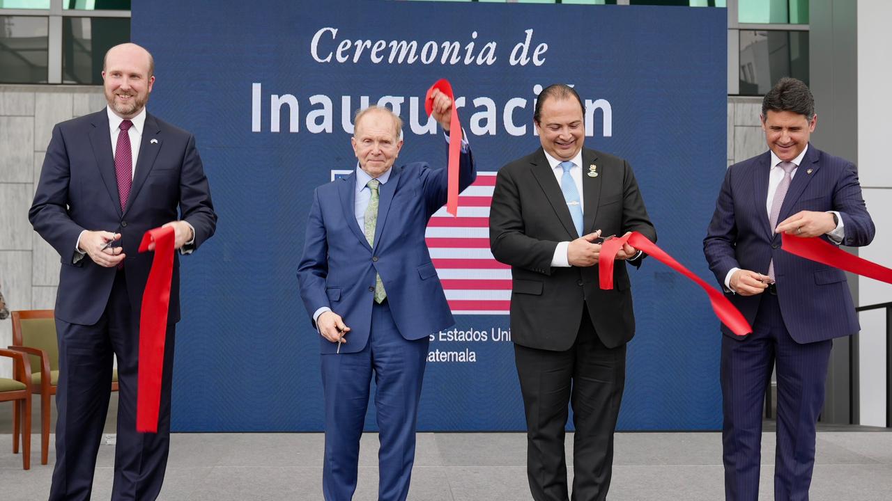 4 men with individual red ribbon pieces cutting with scissors