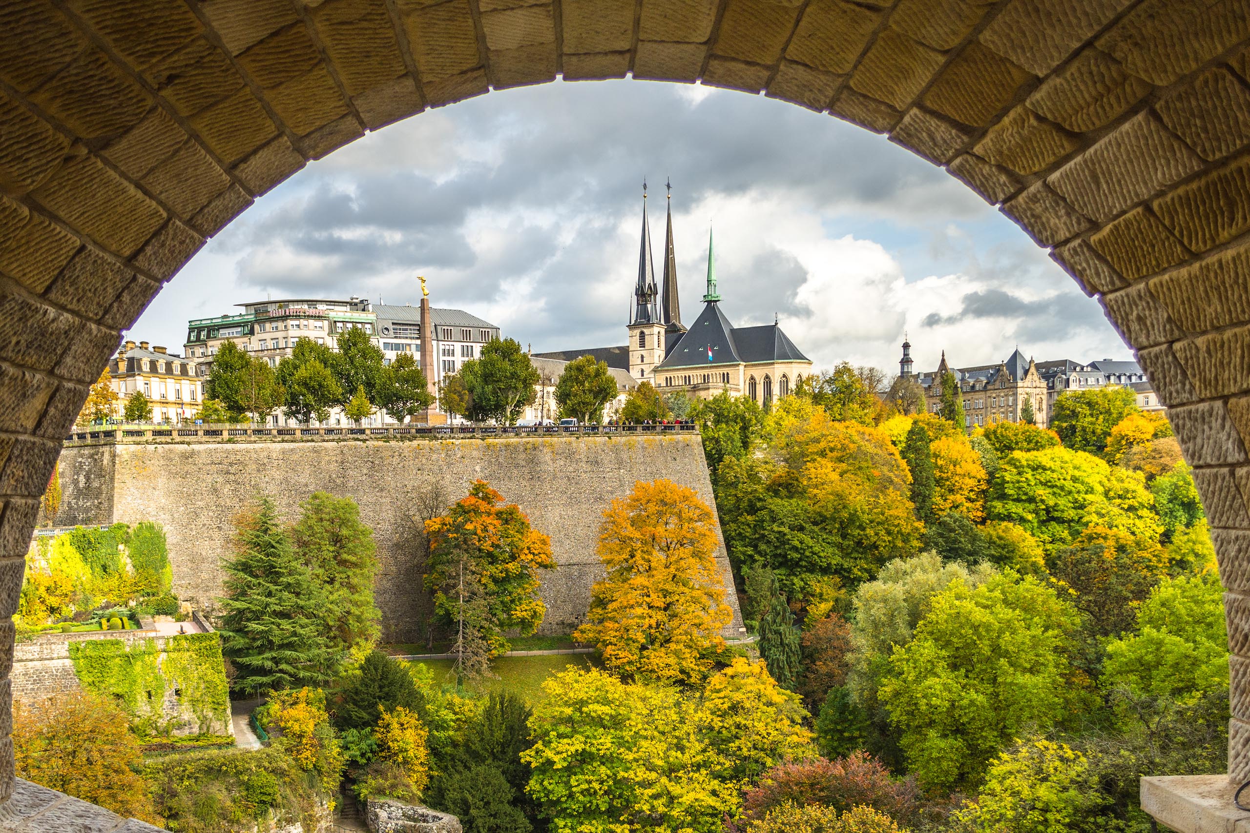 Luxembourg city, Luxembourg - October 12 2017: The view of iconic Gelle Fra and Notre-Dame cathedral in fall from the pedestrian walk under Adolphe bridge in Luxembourg.