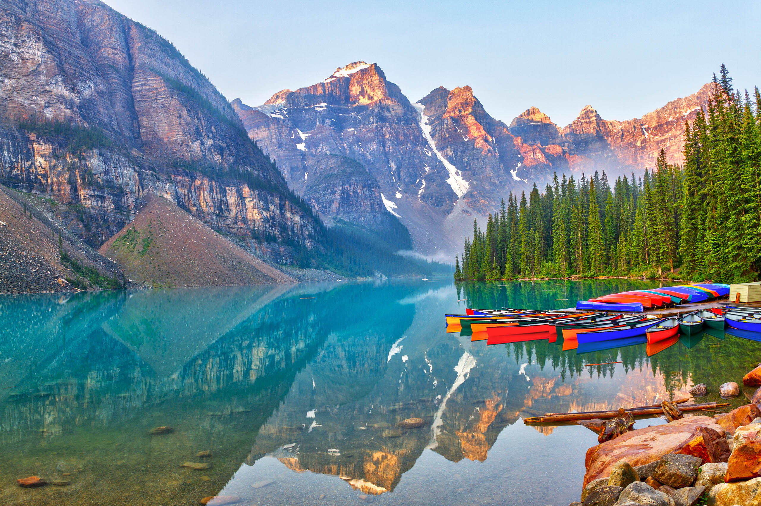 Sunrise over the Valley of the Ten Peaks with canoes on the glacier-fed, turquoise colored Moraine Lake in the Canadian Rockies.