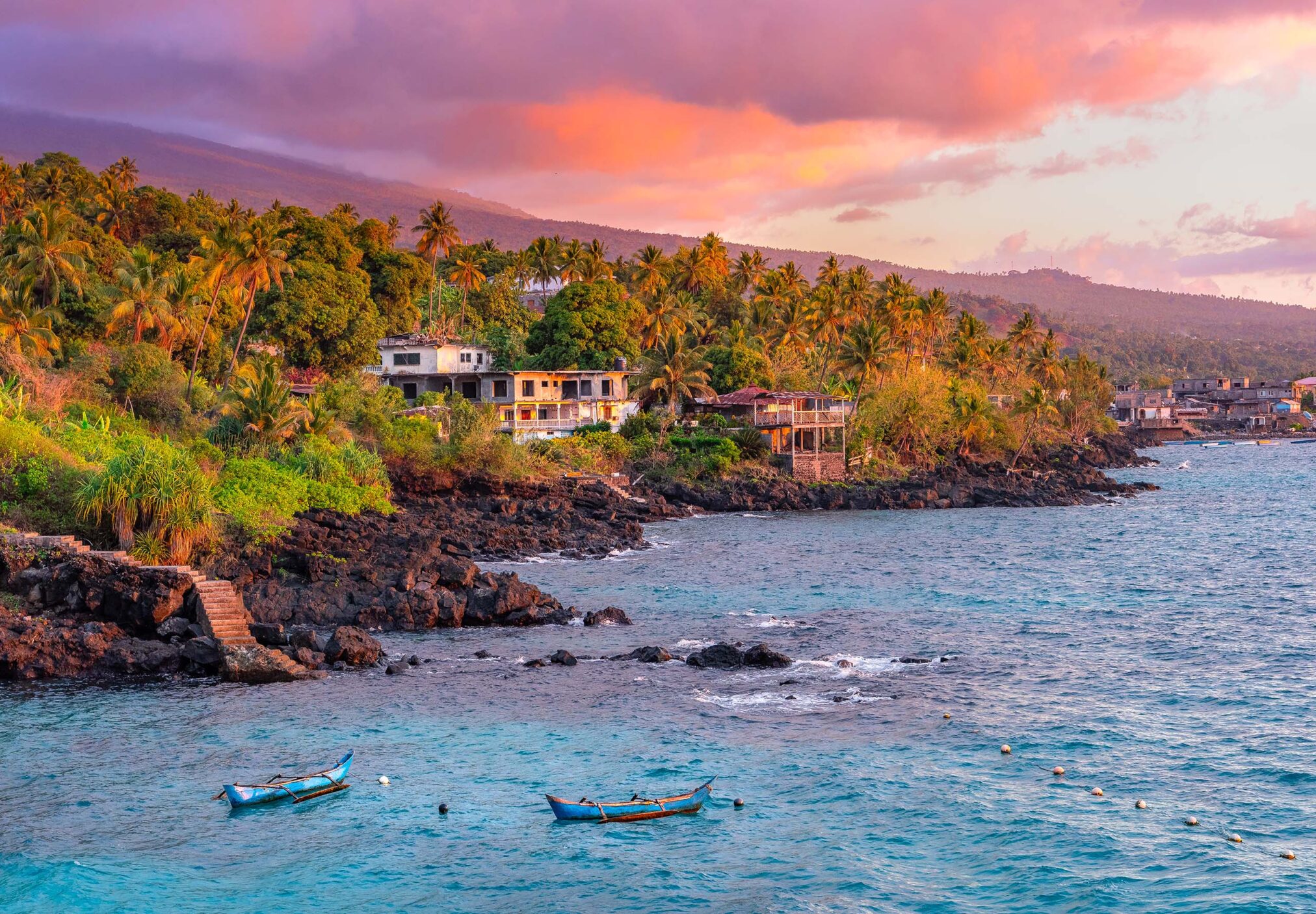 Sunset boats in holiday paradise resort on Grand Comore island, Comoros. Beautiful sunset light of sun in the sea. Villas on the beach with private beach. Moroni Comoros, Itsandra beach resort hotel