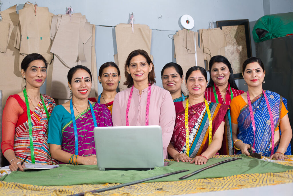 Group,Of,Happy,Indian,Woman,Using,Laptop,By,Sewing,Machine
